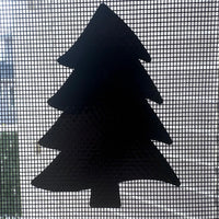 Black silhouette of a Christmas tree on a window screen