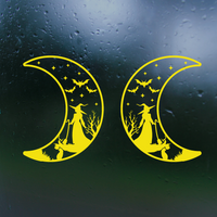 Yellow moon-shaped decals with witch and cat design on a dark surface