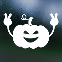 White pumpkin with a face and peace signs on a dark background