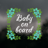 Decorative 'Baby on board' sign with floral design on a dark background