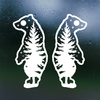 Two white bear-shaped window stickers on a dark textured surface