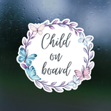 Sticker with 'Child on board' text surrounded by butterflies and leaves on a dark background