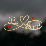 Decorative window sticker with 'Be kind' text and hearts on a rainy window background
