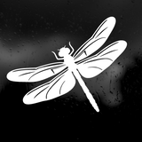 A white dragonfly silhouette decal or sticker shown against a dark, rain-speckled background.