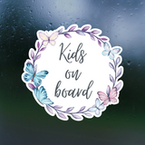 Sticker with 'Kids on board' text surrounded by butterflies and leaves on a dark background